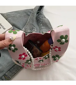 Close-up of pink knit bucket bag interior showing spacious storage with pearl handle