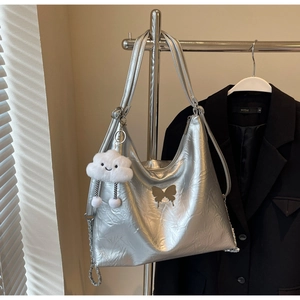 Silver metallic tote bag detail with golden butterfly print and plush cloud charm