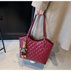 Detail der weinroten Stepp-Tragetasche mit FASHION BAG Text und Plüschhasen-Anhänger