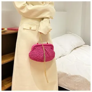 Detailed texture of handmade fuchsia crochet bag with gold chain strap for beach styling