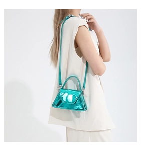 Close-up of glossy turquoise patent leather handbag with metallic finish and top handle