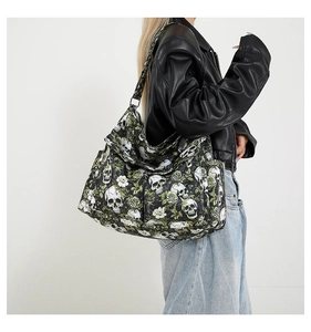 Detail of canvas bag featuring white skulls and roses pattern worn by a model