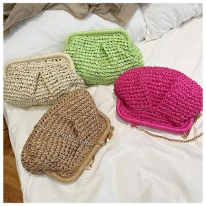 Detail of colorful hand-woven straw crossbody bags with gold metal chain straps