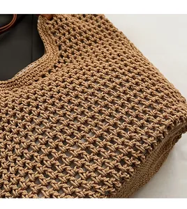 Close-up of hand-woven crochet tote bag with brown mesh pattern and leather handle