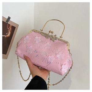 Detail of pink evening bag featuring 3D floral sequins and a crystal butterfly clasp