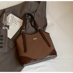 Detail of retro brown patchwork handbag with matte leather and MEIGEER metal logo plate