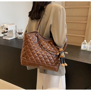 Details der dunkelbraunen gesteppten Leder-Beuteltasche mit süßem Kaninchen-Anhänger