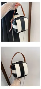 Nahaufnahme der gewebten Würfeltasche mit schwarz-weißen Streifen und braunem Knotengriff