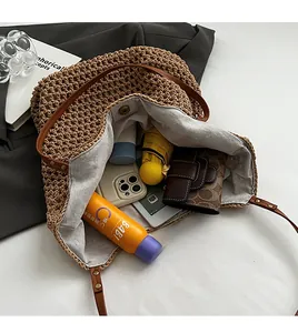 Interior view of large straw bag with leather straps showing daily essentials storage