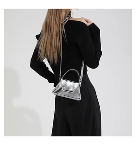 Rear view of model wearing a mini silver metallic mirror handbag over black clothes
