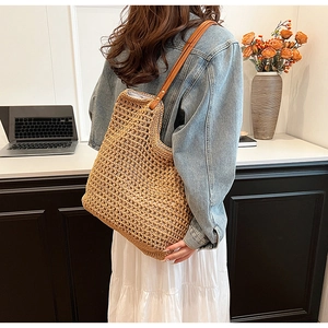 Close-up of handwoven woven cotton tote bag with slim brown leather shoulder straps
