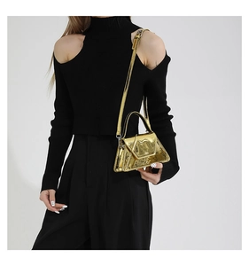 Mirror gold patent leather handbag with adjustable strap shown on a black knit outfit