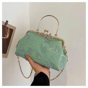 Detail of light green evening bag featuring 3D floral embroidery and golden kiss lock