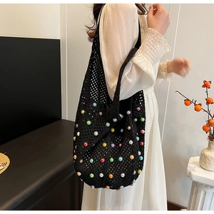 Detailed close-up of woven black tote bag with vibrant multi-colored faux pearl accents