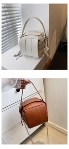 Detail der handgewebten geometrischen Würfeltasche in Creme und Braun mit Metallkette