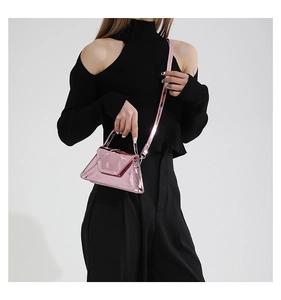 Detailed shot of a triangle glossy pink patent leather handbag with a metallic mirror finish