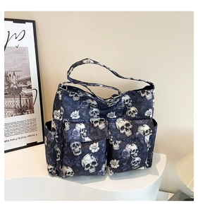 Detail view of canvas tote bag with skull and blue rose print plus front pockets