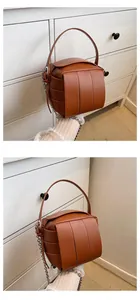 Detailansicht der braunen gewebten Tasche mit breiten Lederriemen und silberner Kette