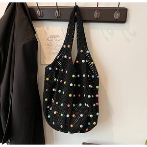 Detail of black crochet tote bag with colorful beads and intricate woven texture