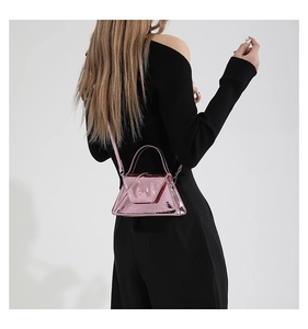 Detail of pink patent leather handbag featuring glossy metallic finish and handle