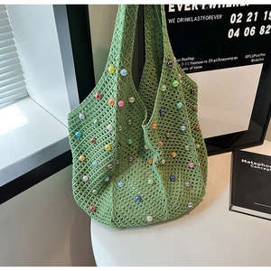 Detail of green woven tote bag with colorful pearl beads and crochet mesh texture