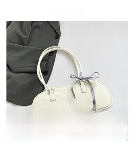 Detail view of white PU leather handbag with ripple texture and plaid silk bow decoration
