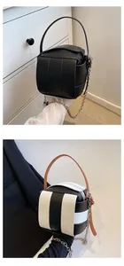 Detailansicht der gewebten Würfeltasche mit dicken Lederriemen und Metallkette