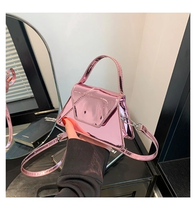 Detailed macro view of the electric pink metallic patent leather finish on mini handbag