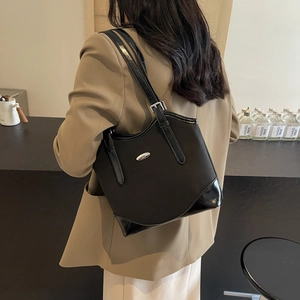 Minimalist black nylon shoulder bag with glossy patent leather base and metal logo detail