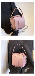Detail der rosa geflochtenen Beuteltasche mit dicken Lederriemen und Silberkette