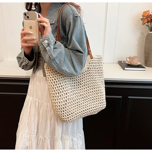 Detail of woven tote bag with ivory cotton mesh texture and brown leather strap