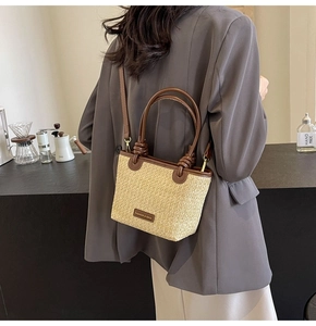Detail of hand-woven straw tote bag with brown leather handle in a lifestyle setting