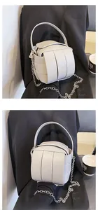 Detailansicht der grauen geflochtenen Beuteltasche mit Lederstreifen und Silberkette
