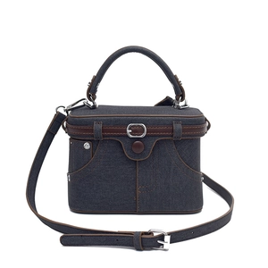 Chic denim box bag with brown leather trim and adjustable crossbody strap on white background