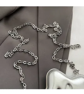 Detail of silver metallic heart bag with sleek hard shell and refined chain strap