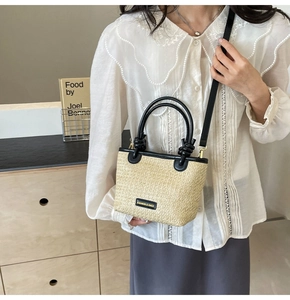 Detail of straw tote bag with black leather trim and detachable shoulder strap