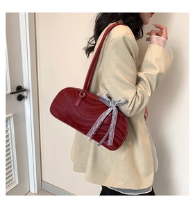 Detail of burgundy wavy pleated shoulder bag with lace bow and plaid ribbon accent