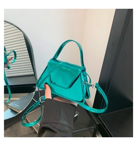 Detail of emerald green patent leather mini bag with trapezoidal geometric design
