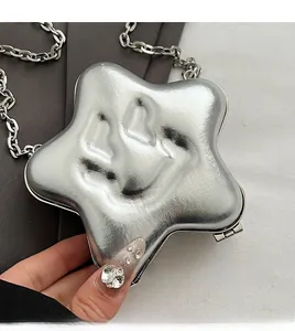 Detail of silver star-shaped crossbody bag with liquid metal texture and chain strap