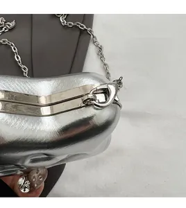 Detail of silver metallic purse showing the detachable ring loop and metal clasp lock