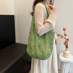 Green handmade crochet hobo bag with colorful beads and minimalist woven design