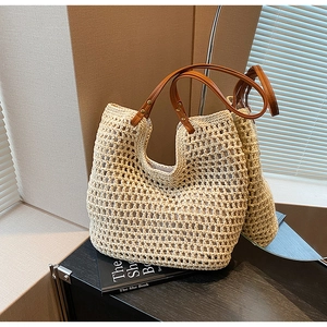 Detail of beige crochet tote bag showing woven texture and brown leather rivet handles