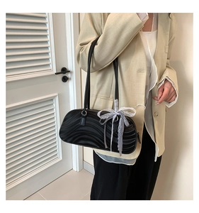 Close-up of black wave pattern PU shoulder bag featuring a decorative lace bow