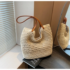 Detailed macro view of woven cream cotton mesh bag with brown leather handles