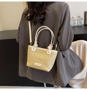 Detail view of large straw tote with white leather trim and Fashion & Bags patch