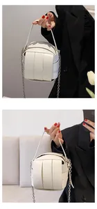 Detail der weißen geflochtenen Würfeltasche mit schmalem Griff und silberner Kette