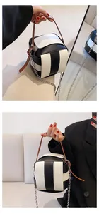 Detail der kontrastierenden Streifen-Eimertasche mit Ledergriff und Metallkettenriemen