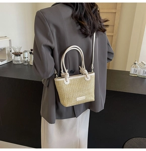 Straw tote bag with white leather straps and fashion label in a lifestyle cafe setting