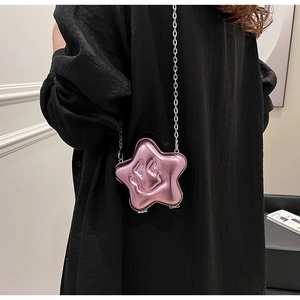 Close-up of pink metallic star-shaped bag with embossed smiley face on chain strap