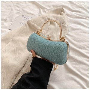 Close-up of light blue sequined evening bag with gold metal handle and jewel clasp